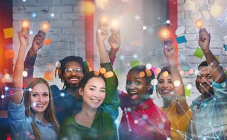 A team of different people holding lightbulbs in their hands.